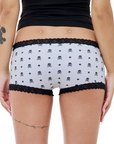 Grey boyshorts with black skull polka dot pattern and lace trim on a white background