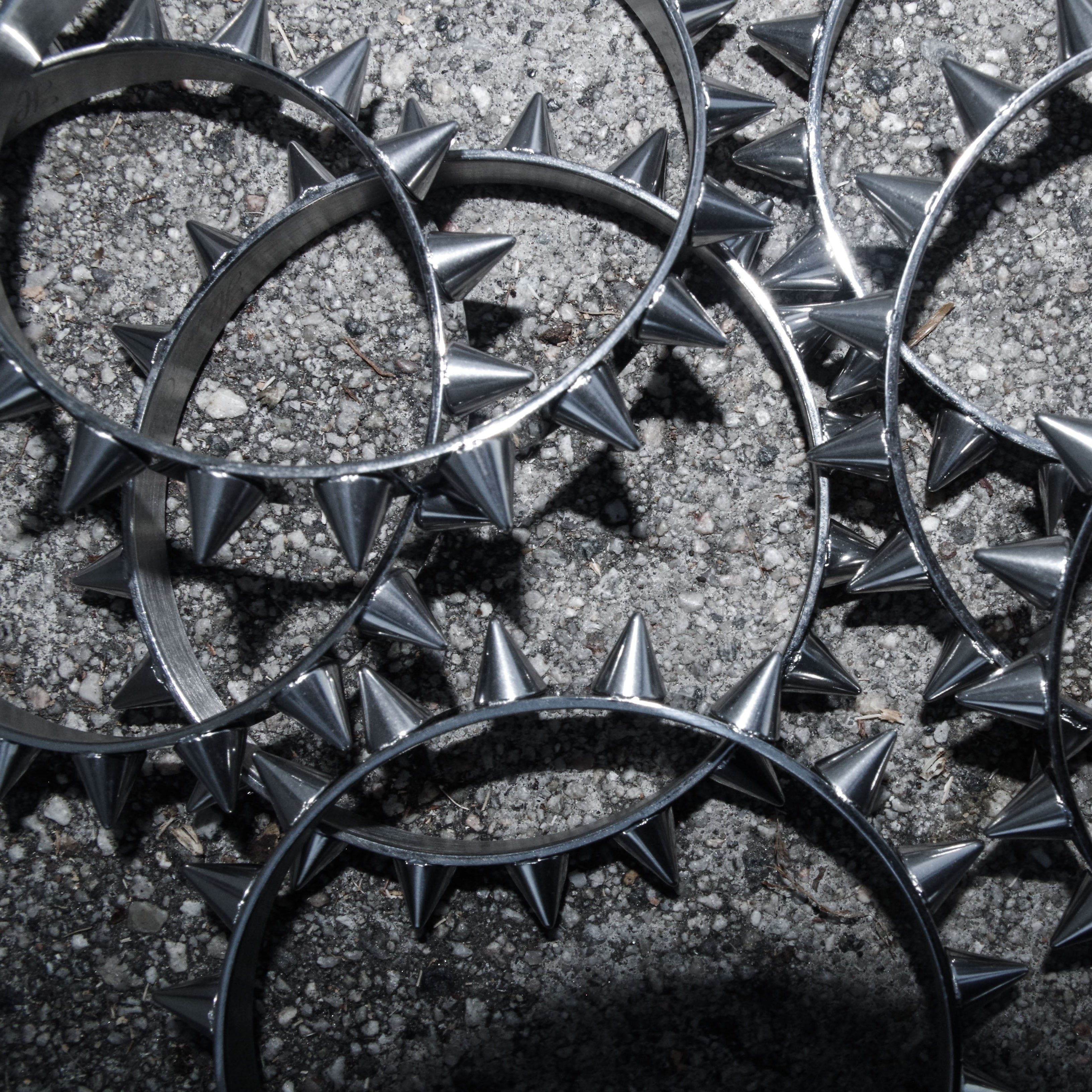 Metal spiked bangles on a textured surface